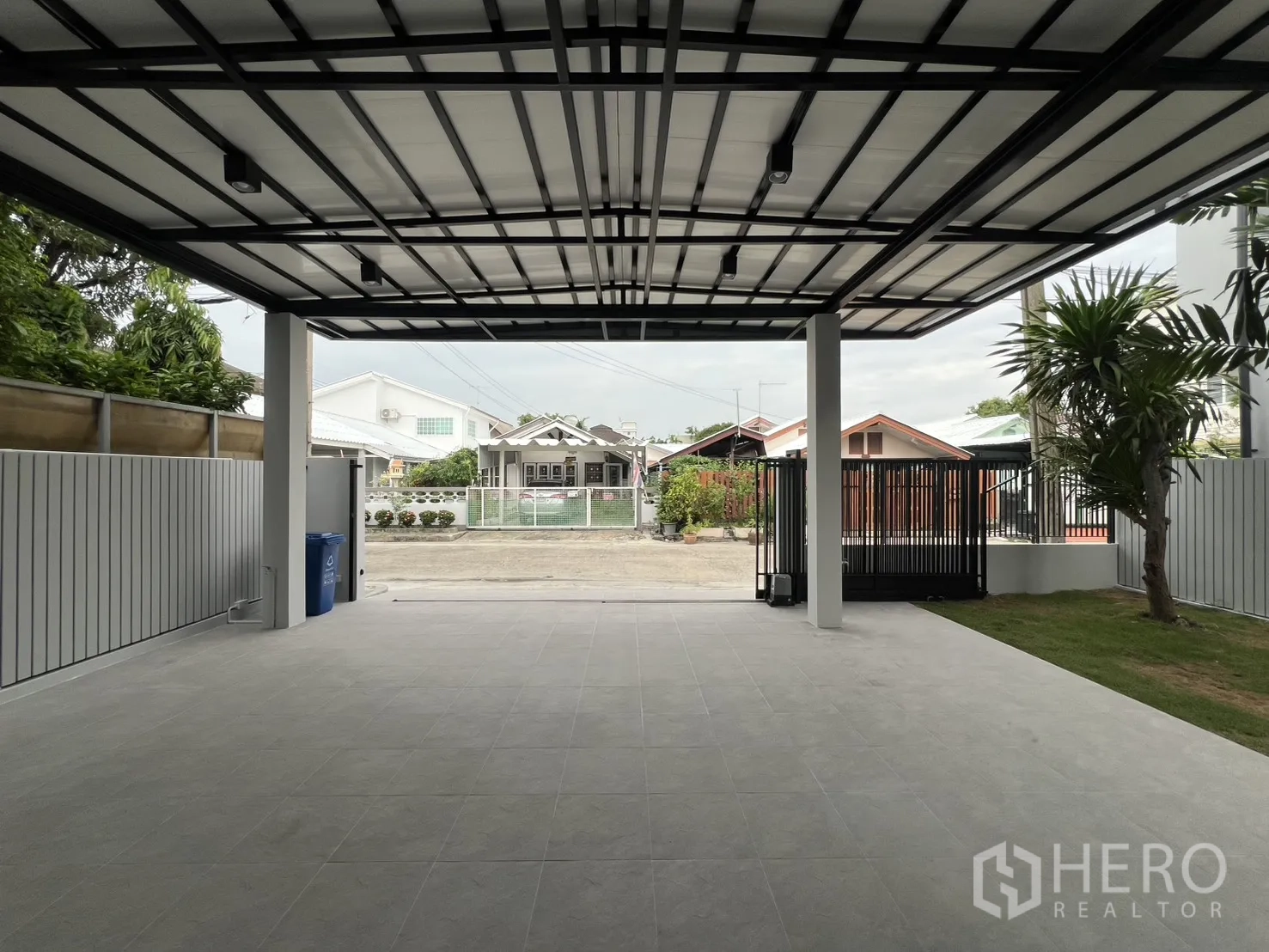 Detached House for rent in Saphan Sung, Bangkok - View of house front from driveway under wide roofed carport.