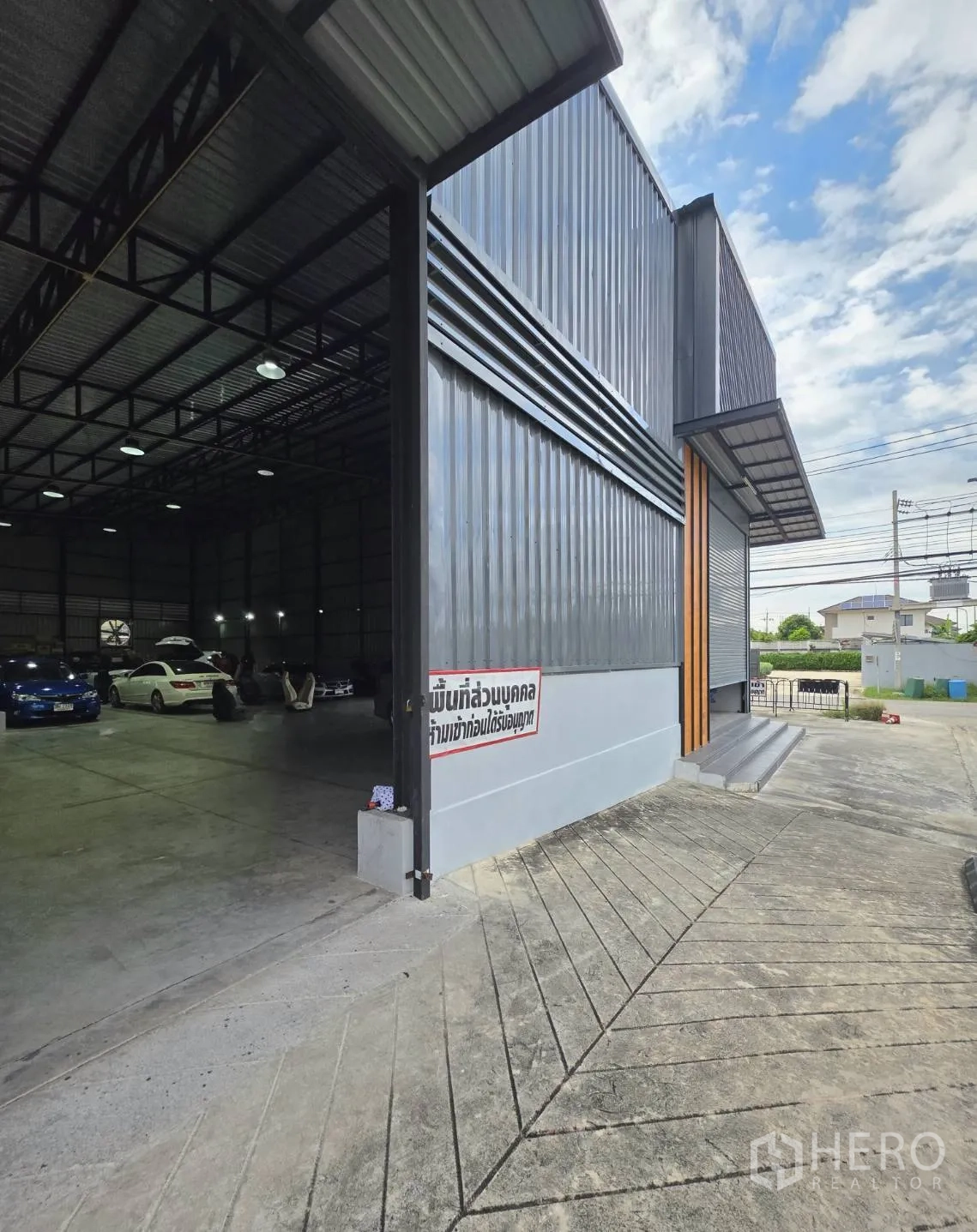 คลังสินค้า ให้เช่าในKhlong Toei, Bangkok - มุมมองด้านข้าง เปิดประตูม้วนเห็นภายในเพดานสูง พร้อมทางลาดสำหรับรถบรรทุก