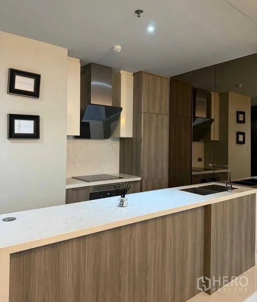 Condominium for rent in Watthana, Bangkok - Open kitchen with long island, wood cabinetry, and stainless range hoods.