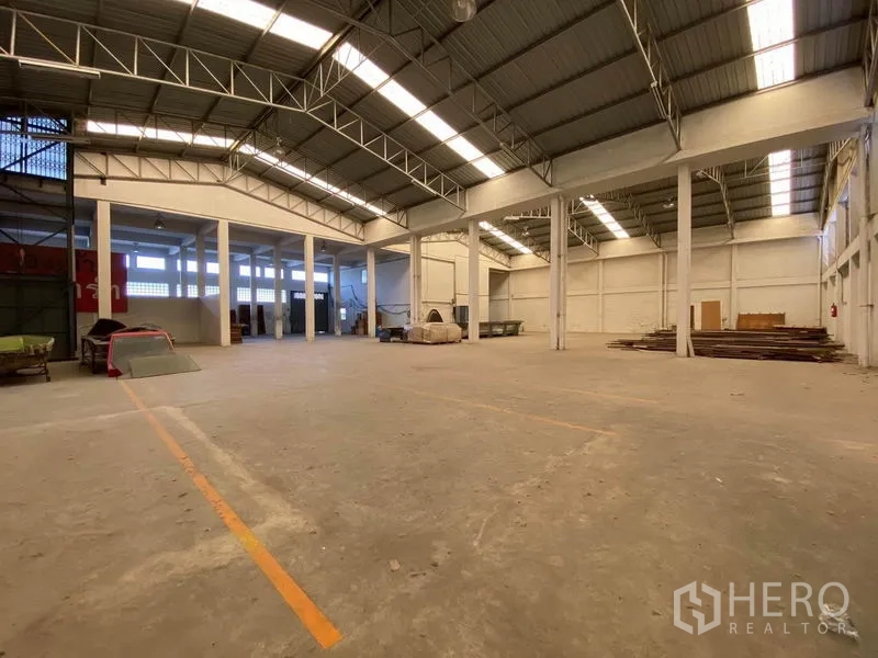 工厂 出售在Bang Phli, Samut Prakan - 宽敞仓库内部，标示通道与天窗