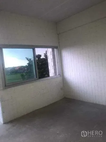 Warehouse for rent in Pathum Thani - Corner room with sliding window, white block walls and view of greenery