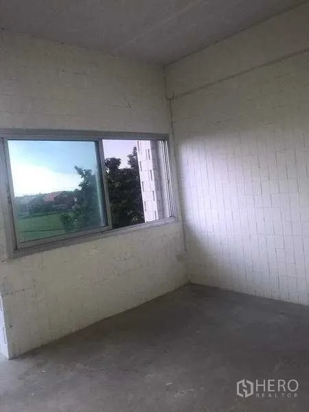 Warehouse for rent in Pathum Thani - Corner room with sliding window, white block walls and view of greenery