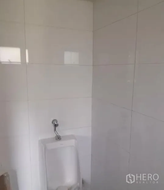 พื้นที่ขายปลีก ให้เช่า - ห้องน้ำปูกระเบื้องสีขาวพร้อมโถปัสสาวะติดผนัง