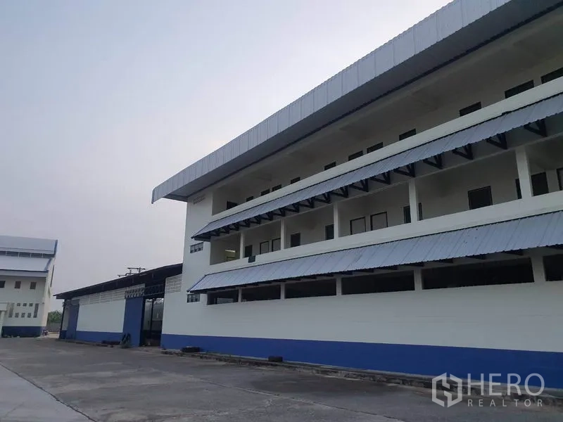 工厂 出租在Bang Bua Thong, Nonthaburi - 办公翼楼近景，长阳台与金属遮篷。