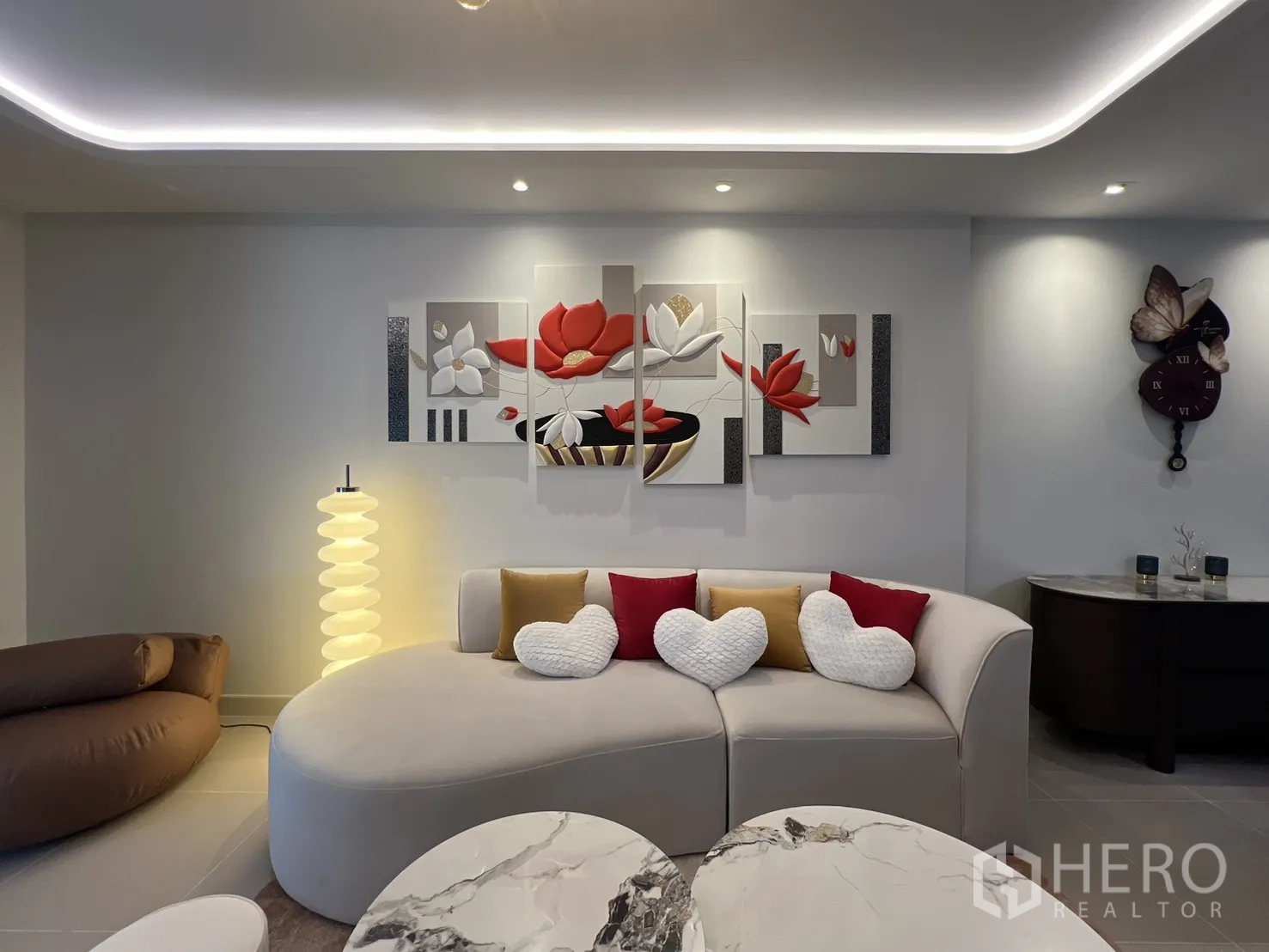 Townhouse for rent in Bang Phli, Samut Prakan - Cozy living area with a curved sofa, decorative wall art and a sculptural floor lamp.