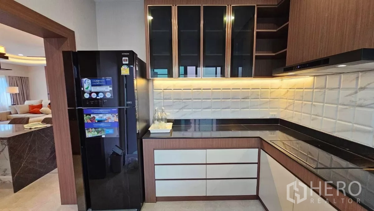 Detached House for rent in Bang Phli, Samut Prakan - Modern kitchen with black refrigerator, stone countertops and tiled backsplash.