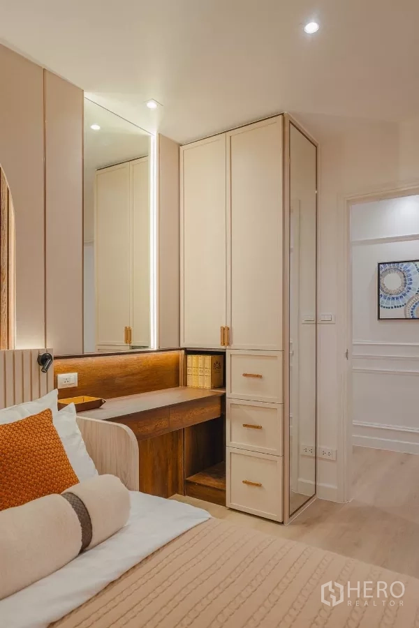 Condominium for rent in Yan Nawa, Bangkok - Corner wardrobe and dressing area with illuminated mirror near the bedroom entrance.