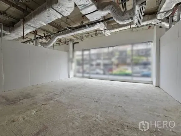 零售空间 出租 - 开放式店铺，白色隔墙与整面落地窗，顶棚机电外露。