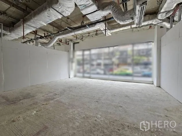 零售空间 出租 - 开放式店铺，白色隔墙与整面落地窗，顶棚机电外露。