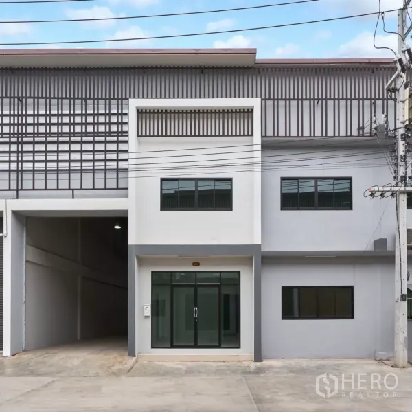 工厂 出租在Mueang Samut Sakhon, Samut Sakhon - 现代两层工厂外立面，带玻璃办公室入口和硬化前院。