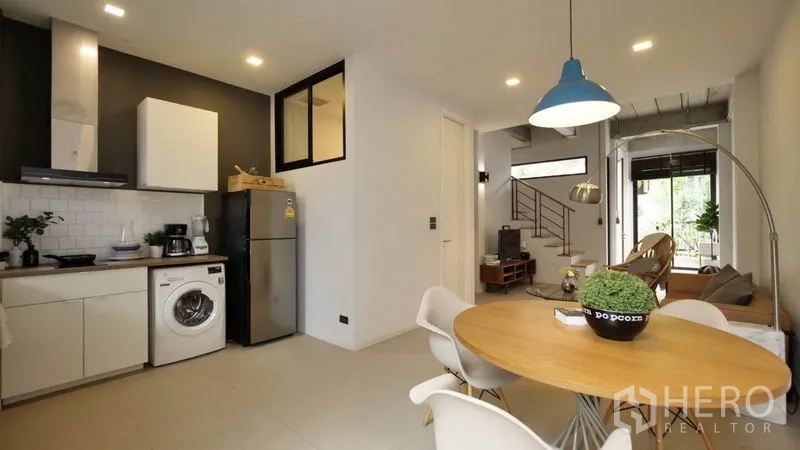 ทาวน์เฮาส์ ให้เช่าในHuai Khwang, Bangkok - ครัวและมุมทานอาหารแบบโอเพ่นแพลน โต๊ะกลม โคมไฟแขวน และมองเห็นโซนนั่งเล่น