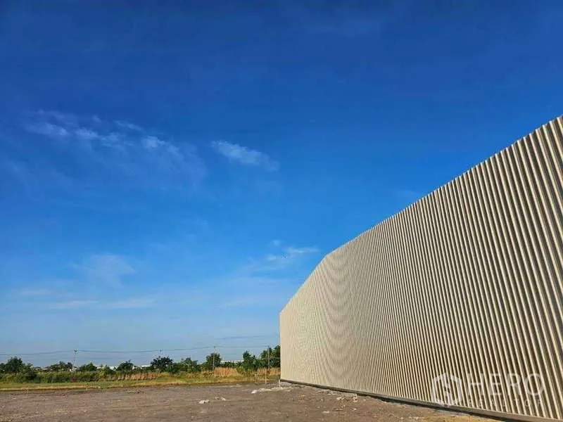 คลังสินค้า ให้เช่าในPak Kret, Nonthaburi - ผนังภายนอกเมทัลชีทของโกดังตัดกับท้องฟ้าสีฟ้า