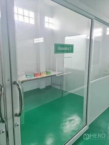 工厂 出售在Bang Pa-in, Phra Nakhon Si Ayutthaya - 标示“包装室2”的玻璃房，配长工作台与容器。