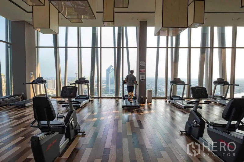 Condominium for sale - Sky gym with floor-to-ceiling glass offering panoramic city and river views.