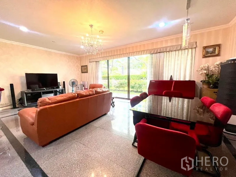 คอนโด ขายในPathum Wan, Bangkok - มุมพักผ่อนสว่างไสว โซฟาหนัง ทีวี และหน้าต่างกระจกสูงเต็มบานรับวิวสวน