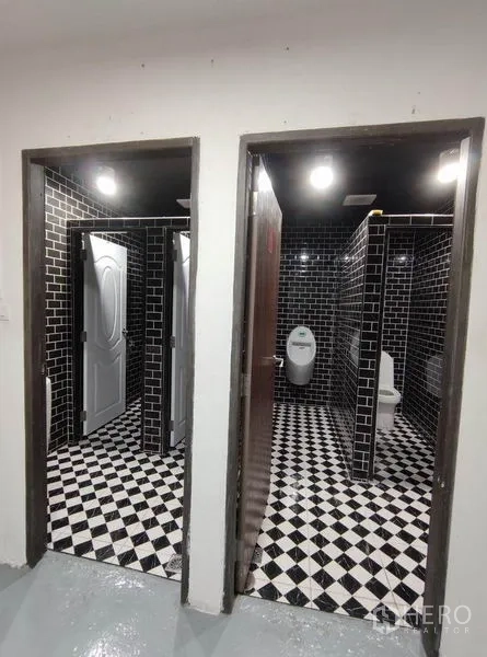 Warehouse for rent in Bang Phli, Samut Prakan - Restrooms with black subway tiles and black-and-white checkered floors.
