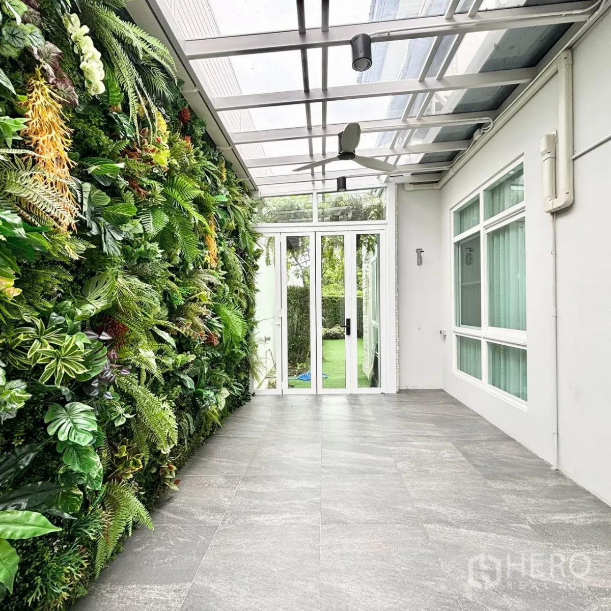 บ้าน ให้เช่าหรือขายในPrawet, Bangkok - เฉลียงหลังคากระจก พร้อมผนังสวนแนวตั้ง เข้าสู่สนามหญ้าหลังบ้าน