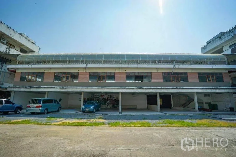 零售空间 出租在Watthana, Bangkok - 两层商业楼外观，带有遮雨车位和大窗户，位于瓦他那区Ekkamai。