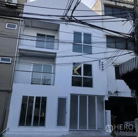 Home Office for rent in Khlong Toei, Bangkok - Modern white multi-storey home office facade with large windows and streetfront glazing.