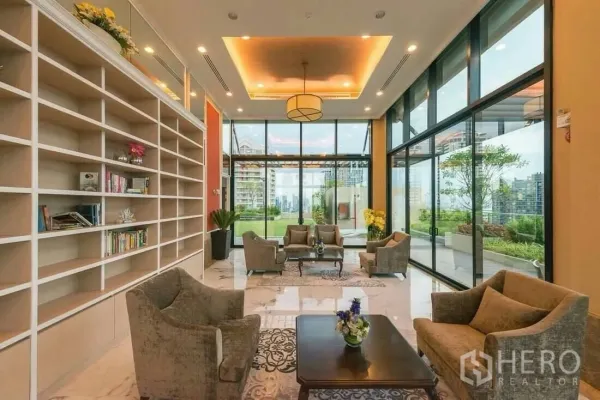 Condominium for rent in Sathon, Bangkok - Residents’ lounge with library shelves, sofa seating and views to a garden terrace at the condominium.