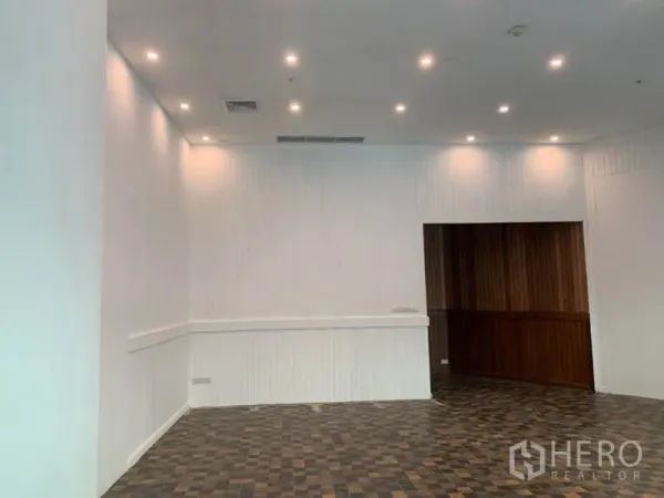 零售空间 出租在Khlong Toei, Bangkok - 开放式零售区域，高挑天花与射灯，搭配木质特色墙面。