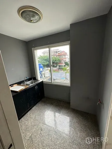 ทาวน์เฮาส์ ให้เช่าในBang Kapi, Bangkok - ครัวขนาดกะทัดรัด มีหน้าต่าง เคาน์เตอร์สีดำ อ่างสแตนเลส และวิวชุมชน