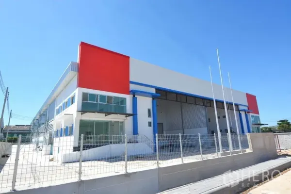 工厂 出租在Mueang Samut Prakan, Samut Prakan - 现代半独立式工厂外观，玻璃立面办公室与红色点缀，围栏完善，位于邦普工业区。