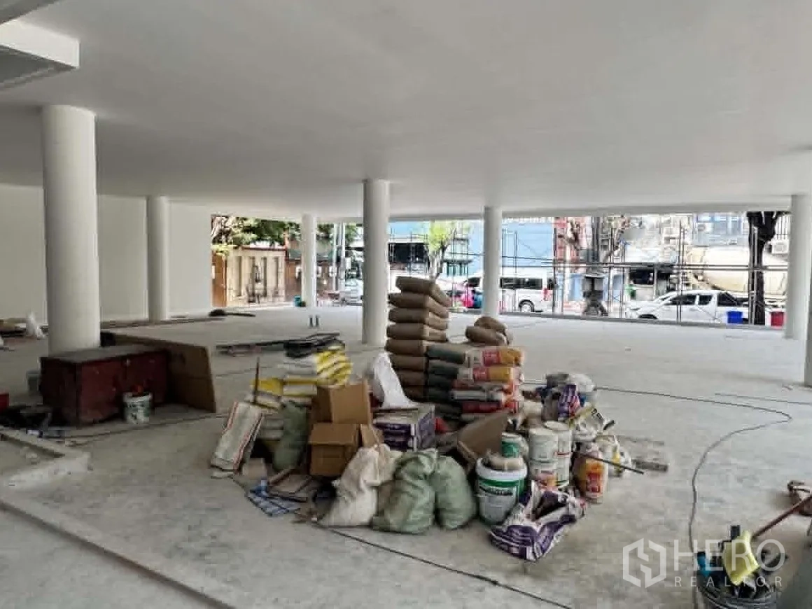 Retail Space for rent in Watthana, Bangkok - Open interior with building materials stacked at the center.