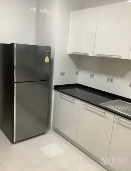 ทาวน์เฮาส์ ให้เช่าในKhlong Toei, Bangkok - มุมครัวพร้อมตู้เย็นสแตนเลส เคาน์เตอร์สีดำ และตู้บิลท์อิน