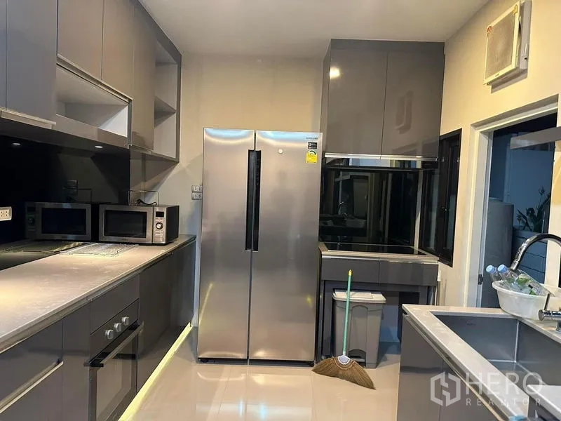 Detached House for rent in Bang Phli, Samut Prakan - Modern kitchen with stainless side-by-side refrigerator and ample cabinetry.