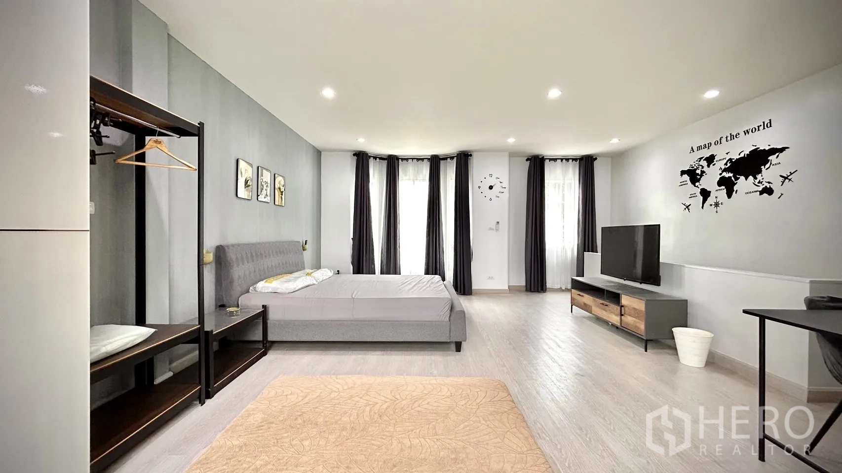 Townhouse for rent in Bang Kapi, Bangkok - Master bedroom view with bay windows, TV stand and open wardrobe system.