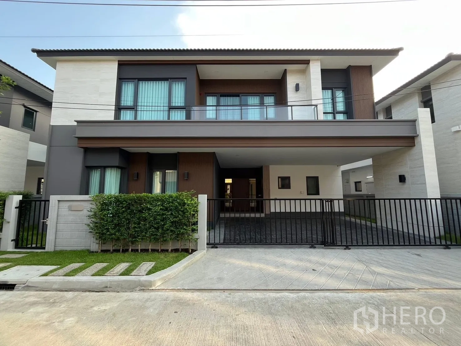 Detached House for rent in Bang Phli, Samut Prakan - Modern two-storey detached house exterior with gated covered carport and balcony.