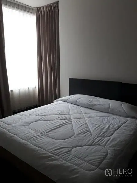 คอนโด ให้เช่าหรือขายในWatthana, Bangkok - ห้องนอนอบอุ่นพร้อมเตียงคู่ หัวเตียงบุนุ่ม และหน้าต่างบานใหญ่มีผ้าม่าน ในคอนโดมิเนียมสมัยใหม่