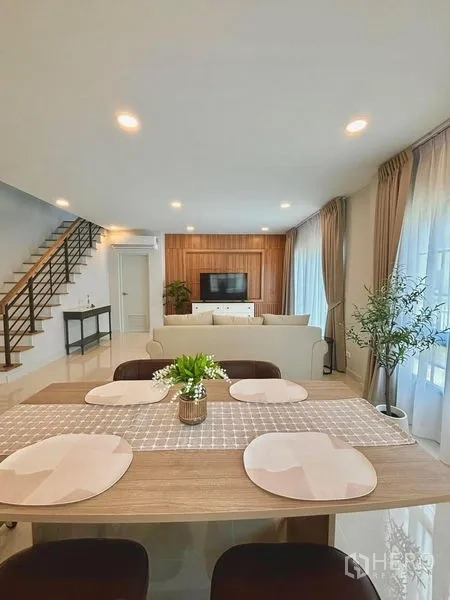 Detached House for rent in Bang Phli, Samut Prakan - Open-plan dining and living area with staircase, recessed lighting and large windows.