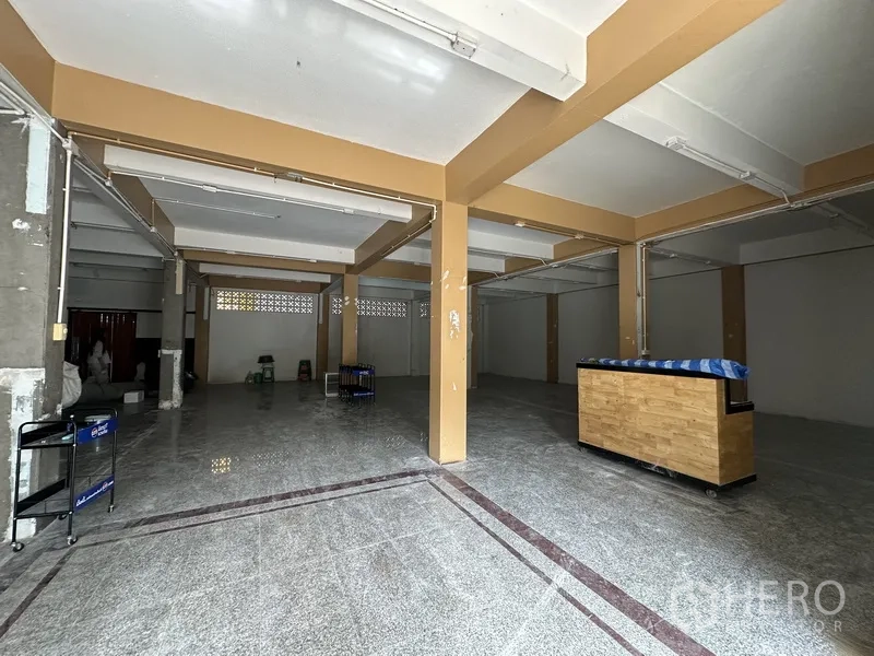 พื้นที่ขายของ for rent in Bang Rak, Bangkok - พื้นที่ร้านค้าพร้อมเสาสีเบจและเคาน์เตอร์ไม้เคลื่อนย้ายได้
