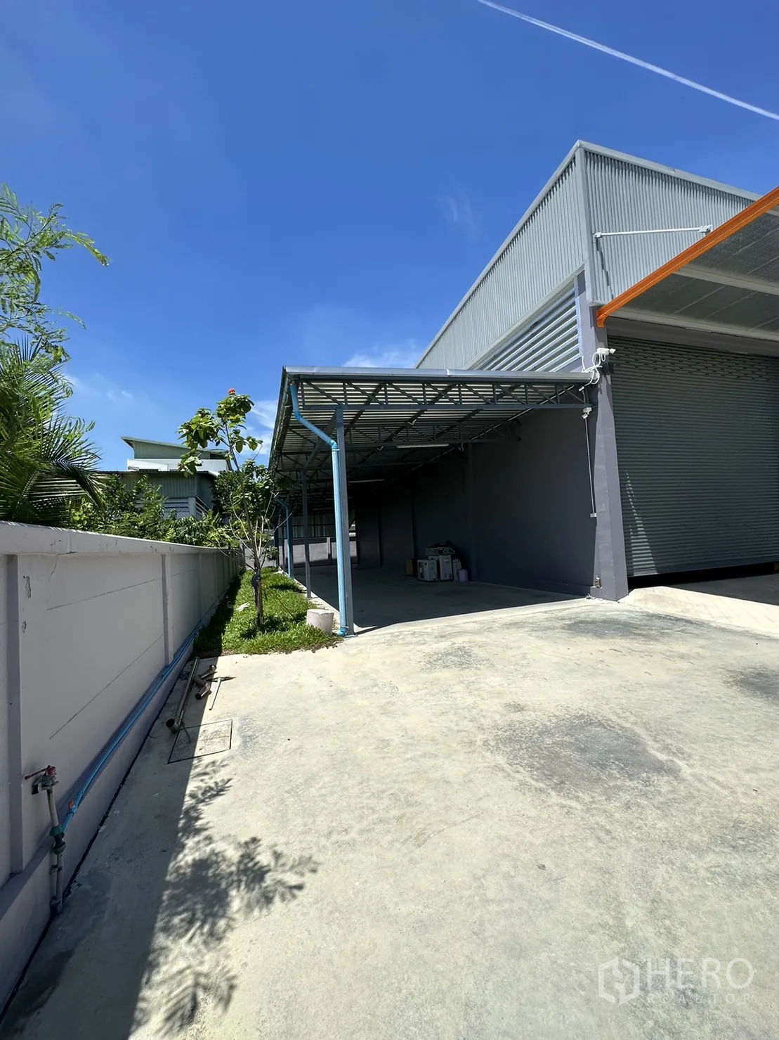 โรงงาน ขายในLam Luk Ka, Pathum Thani - ลานข้างอาคารมีหลังคาและพื้นที่สีเขียวริมกำแพง.