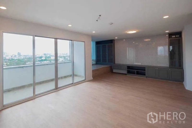 คอนโด ขายในChatuchak, Bangkok - ห้องนั่งเล่นแบบเปิดโล่ง ประตูกระจกบานเลื่อนออกสู่ระเบียง และผนังทีวีบิลท์อิน