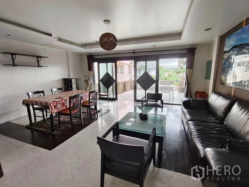Townhouse for rent or sale in Bang Kho Laem, Bangkok - Family lounge and dining area opening to a large terrace via sliding glass doors.