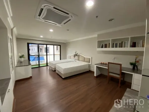 คอนโด ให้เช่าในWatthana, Bangkok - ห้องนอนเตียงเดี่ยวสองเตียง พร้อมโต๊ะทำงาน ชั้นวาง และประตูกระจกบานเลื่อนไปยังระเบียง