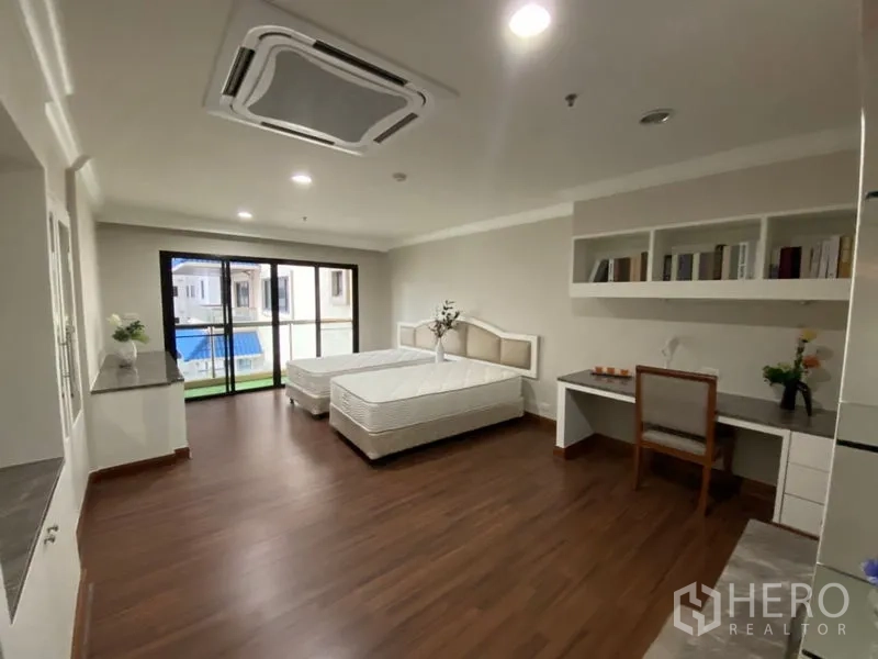 คอนโด ให้เช่าในWatthana, Bangkok - ห้องนอนเตียงเดี่ยวสองเตียง พร้อมโต๊ะทำงาน ชั้นวาง และประตูกระจกบานเลื่อนไปยังระเบียง