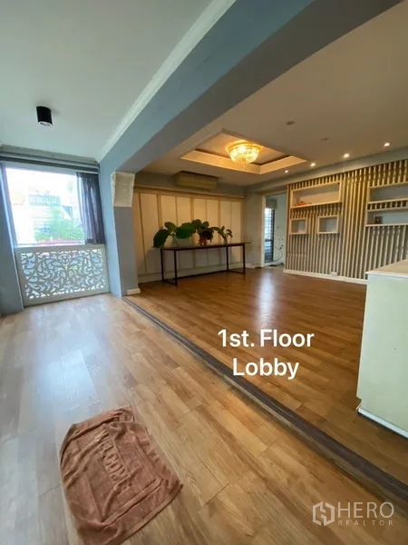Home Office for rent or sale in Suan Luang, Bangkok - First‑floor lobby with wood flooring, recessed ceiling lighting and a feature wall.