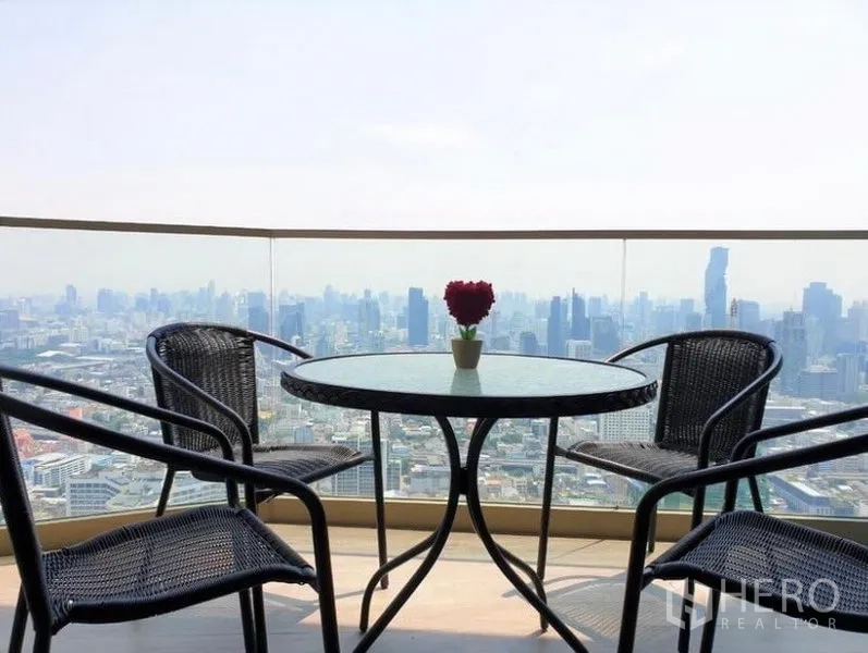 คอนโด ให้เช่าในKhlong San, Bangkok - ระเบียงชั้นสูงพร้อมโต๊ะกลมและเก้าอี้ ชมทิวทัศน์สกายไลน์กรุงเทพฯ