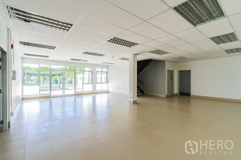 Warehouse for rent in Phra Nakhon Si Ayutthaya - Bright office area inside the warehouse complex with floor-to-ceiling glass, tiled flooring, drop ceiling lights and an internal staircase.