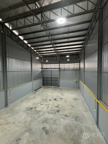 货栈 出租在Mueang Pathum Thani, Pathum Thani - 俯视钢结构桁架屋顶，照明充足，面向主装卸门。