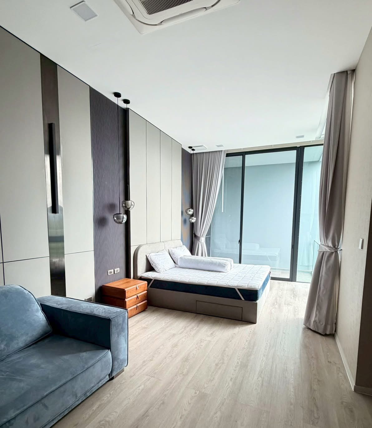 Detached House for rent in Saphan Sung, Bangkok - Guest bedroom with bed, armchair, pendant lights and sliding doors to a balcony.