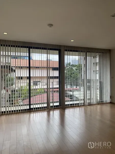 คอนโด ให้เช่าในPathum Wan, Bangkok - ห้องนั่งเล่นคอนโดสว่าง ผนังกระจกเต็มบาน ม่านปรับแสง และพื้นไม้ มองเห็นบรรยากาศปทุมวัน