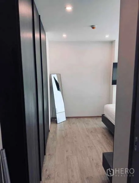 Condominium for rent in Khlong Toei, Bangkok - Hallway dressing area with full-length mirror and wardrobes.