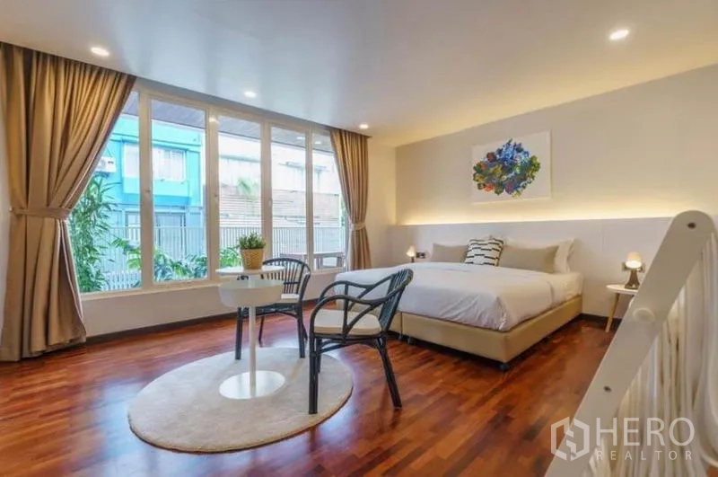 ทาวน์เฮาส์ ให้เช่าในKhlong Toei, Bangkok - ห้องนอนรับแสงธรรมชาติ เตียงคิง มุมนั่งเล่น และหน้าต่างสูงจรดพื้นบนพื้นไม้