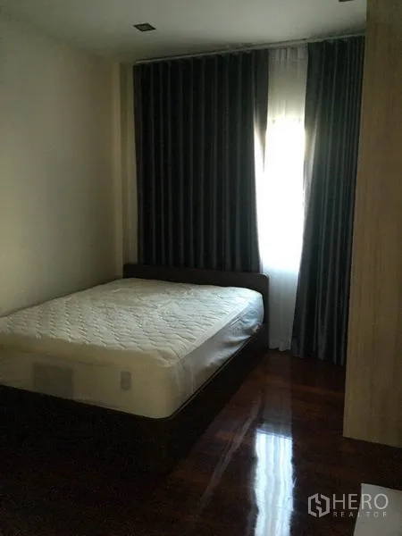 独立式住宅 出售在Khlong Toei, Bangkok - 温馨卧室，双人床，深色窗帘与木地板。