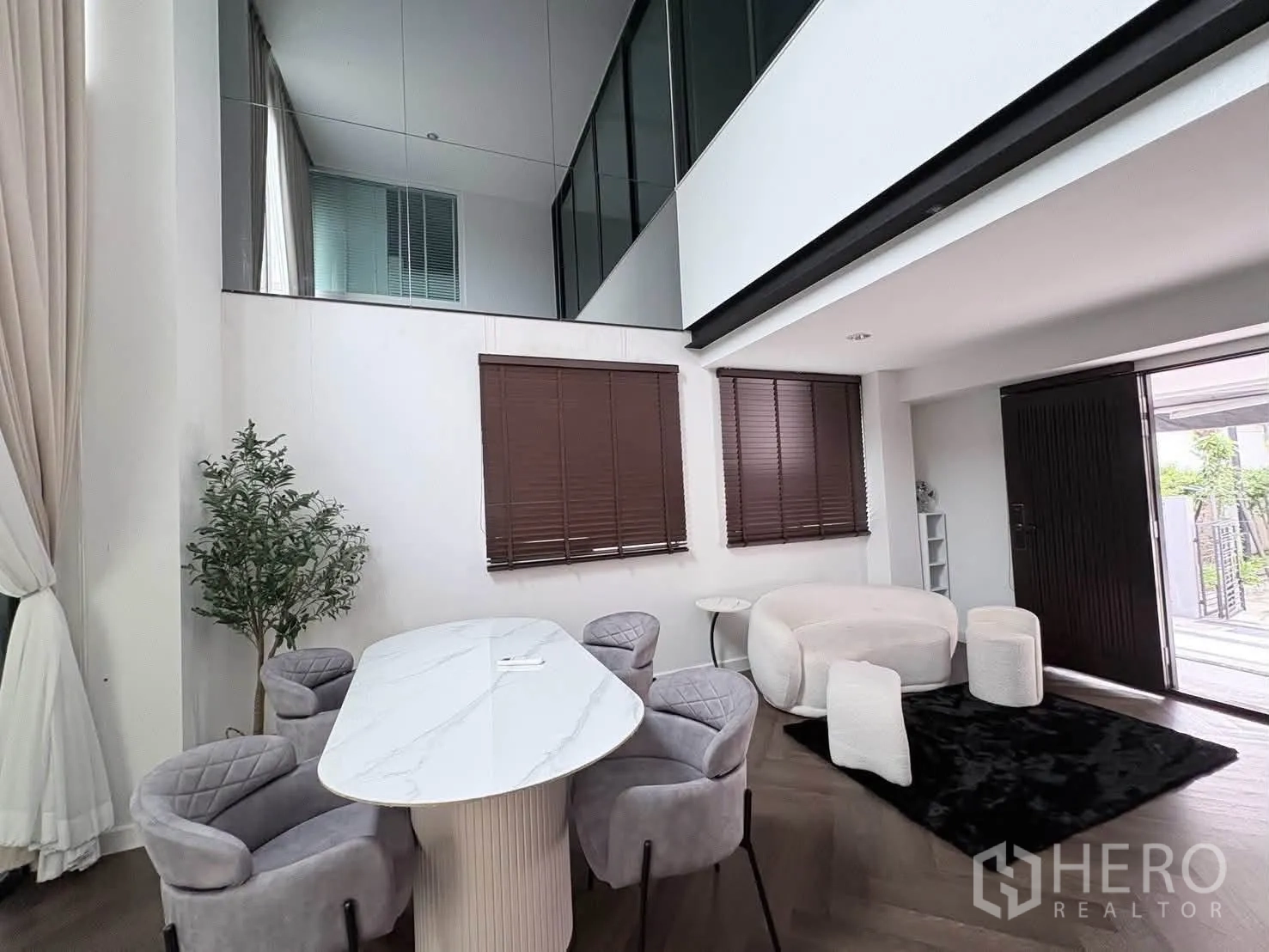 Detached House for rent in Saphan Sung, Bangkok - Double-height dining and living space with marble-top table, upholstered chairs, and window blinds.